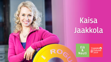 Kaisa Jaakkola pinkki huppari päällään leveästi hymyillen nojaa levypainoon vieressään Elä & Nauti | Tykkää & Tuhulaa logo