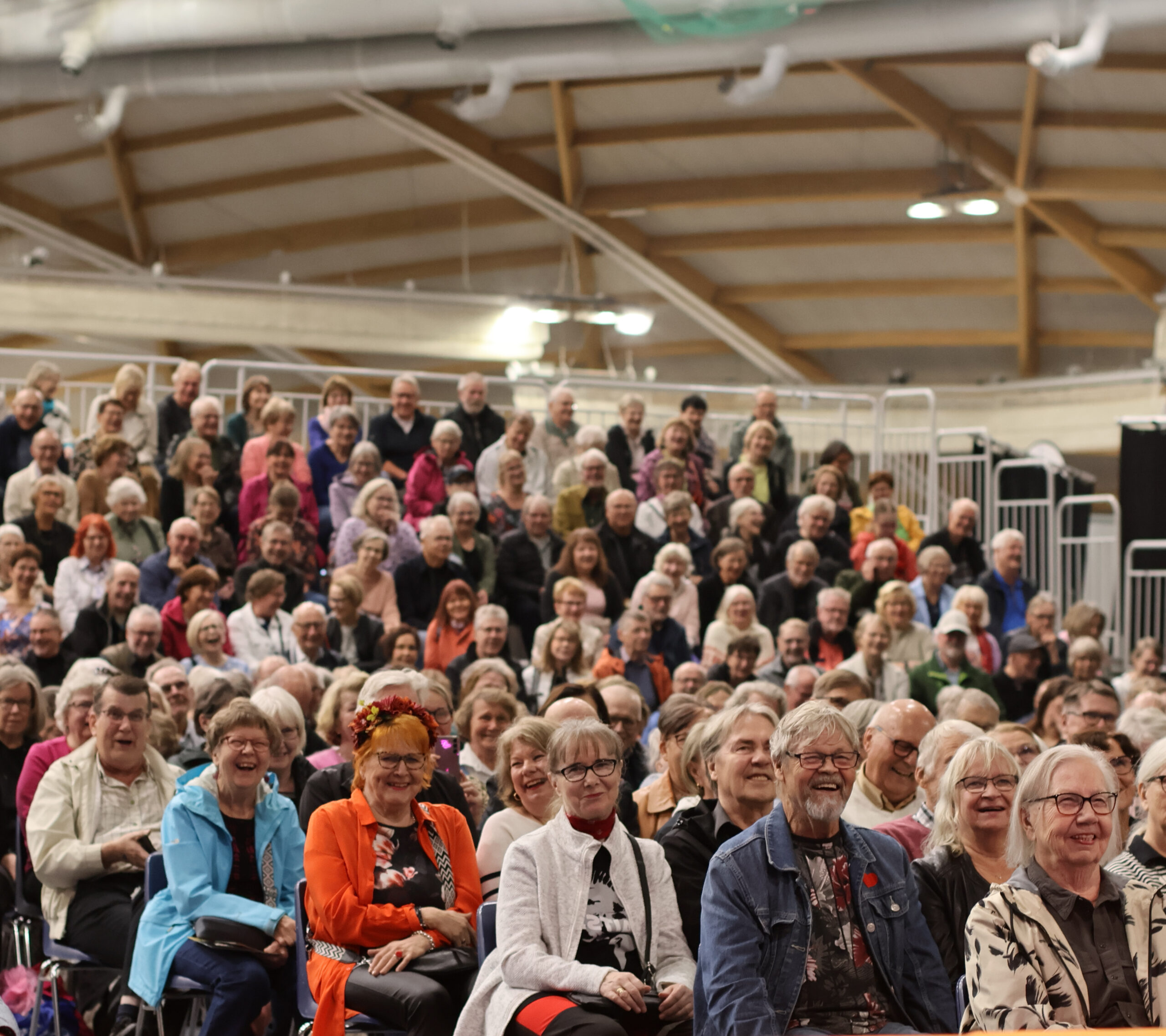 Iäkkäämmät ihmiset nauravat yleisössä Seniorimessuilla Ouluhallissa